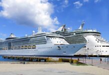 A big cruise ship next to a small cruise ship