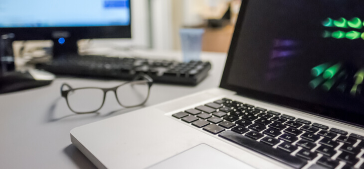 laptop and eyeglasses sitting on desk