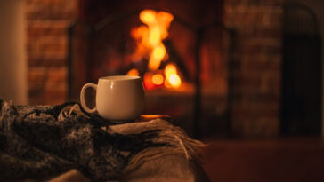 cup of tea and blanket in front of fire