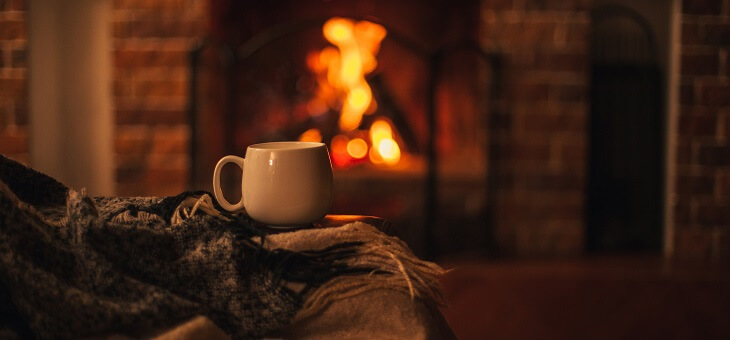 cup of tea and blanket in front of fire