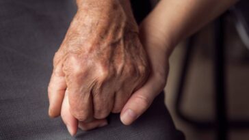 Carer holding hands with a patient