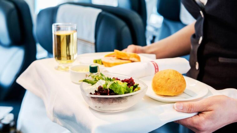 Flight attendant serving airplane meal