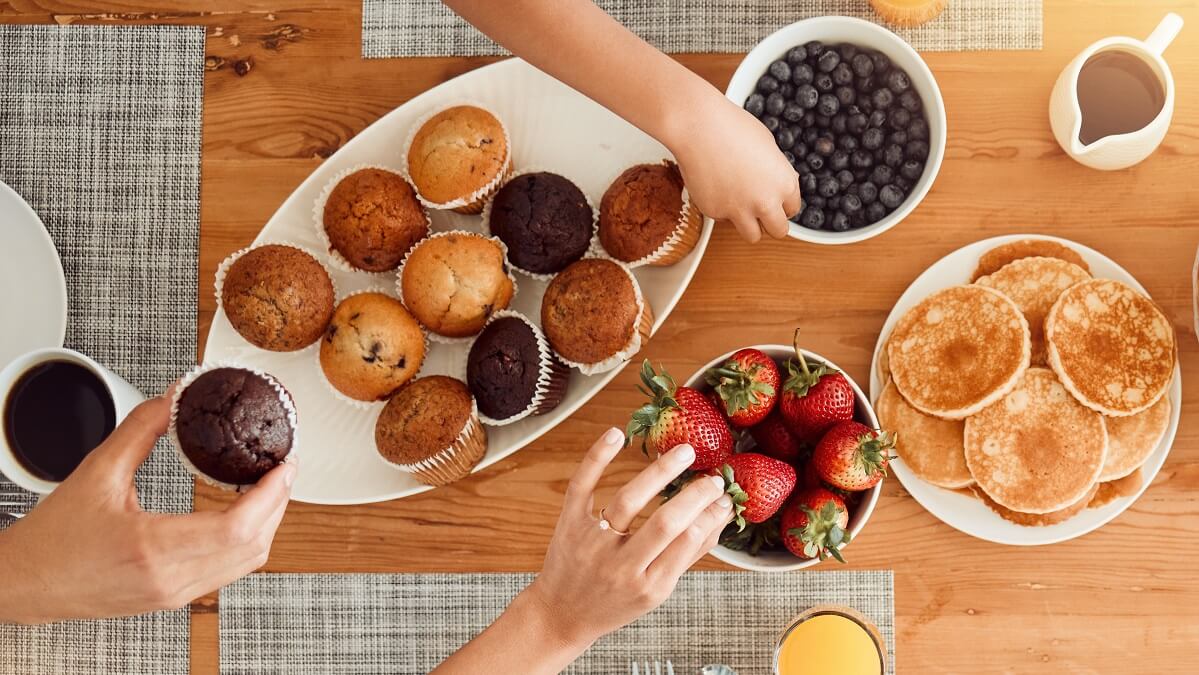 friends sharing plate of muffins