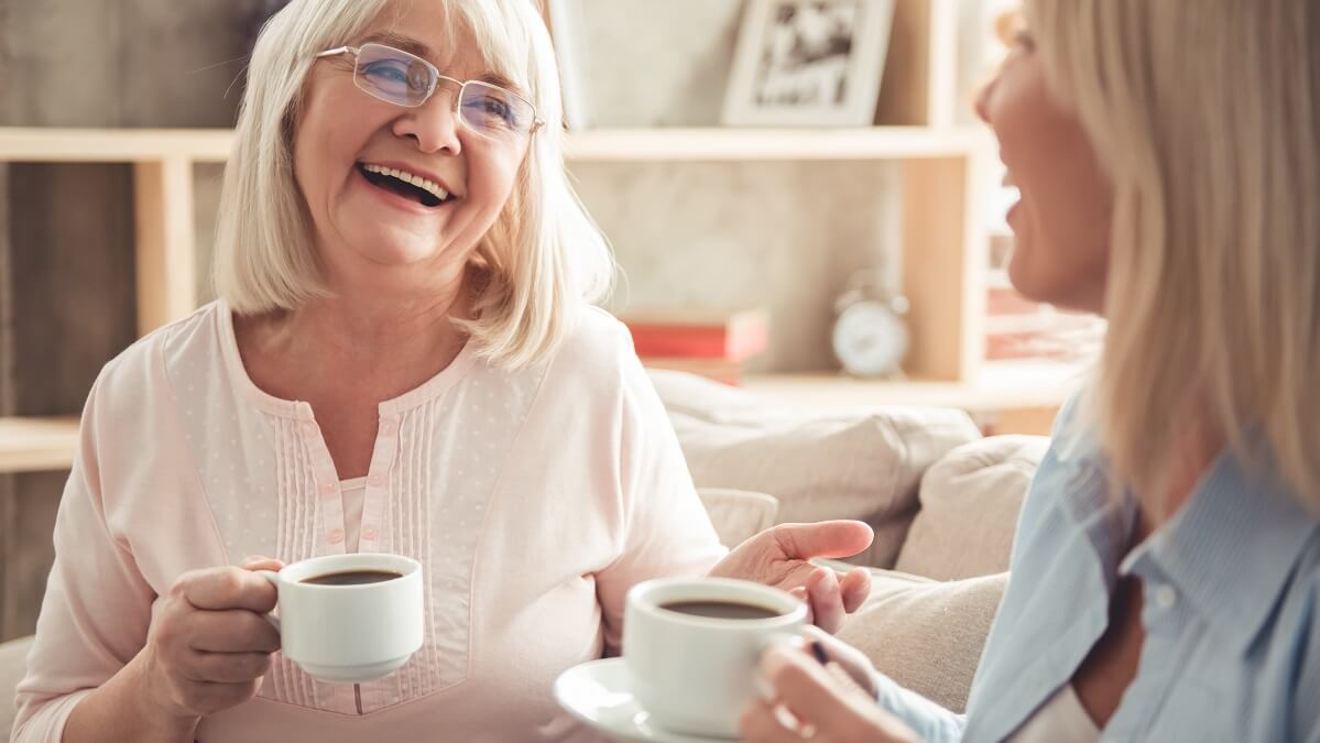two women laughing over coffee