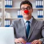 man wearing suit and clown nose in office