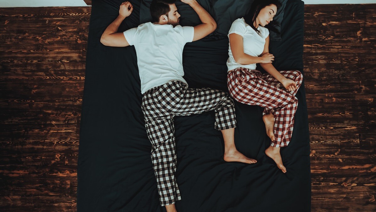 man and woman in different sleep positions