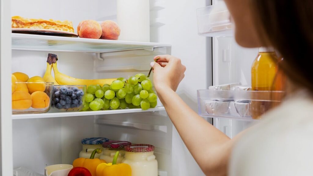 woman opening environmentally friendly fridge