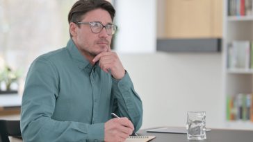 Middle aged man looks thoughtful as he considers canceling his health insurance