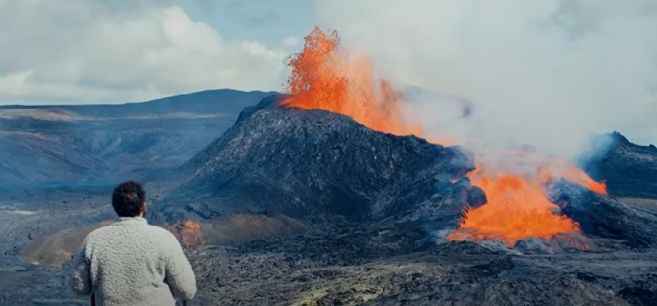 man standing in front of icelandic volcano