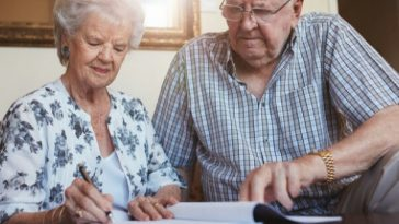 older couple on couch writing plan