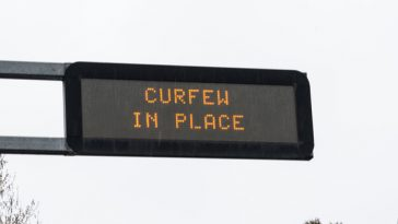 digital roadsign displaying curfew warning