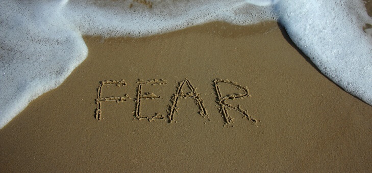 the word fear written in sand on beach