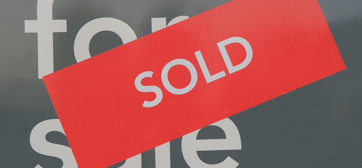 real estate for sale sign with sold sticker