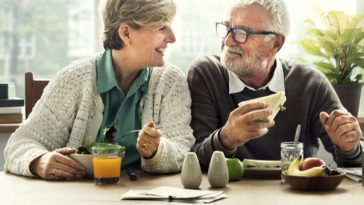 happy older couple sitting at breakfast table