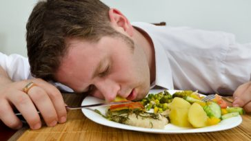 man sleeping in plate of food