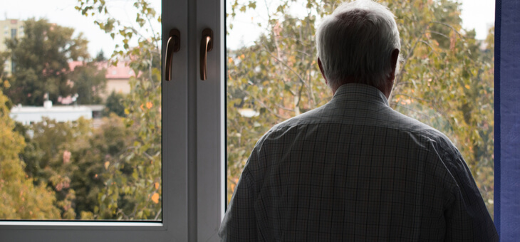 rear view lonely older man staring out window