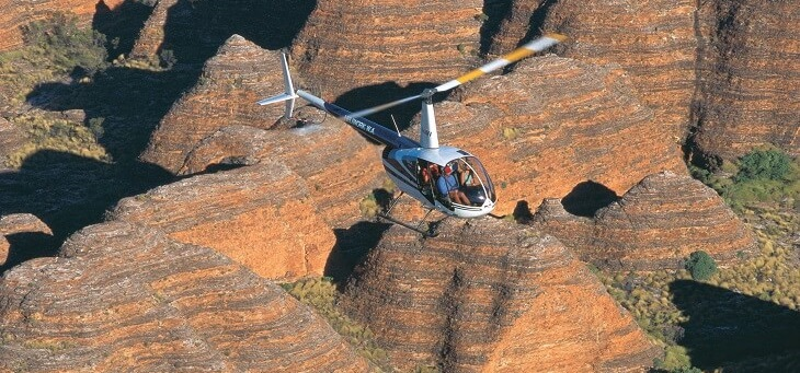 helicopter flying over bungle bungle rock formation