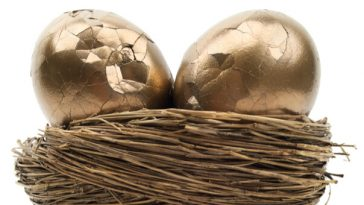 two cracked golden eggs in a nest