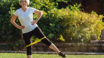 woman stretching legs with resistance band