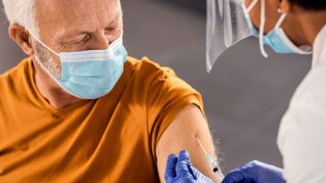 older man getting injection from nurse