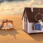 model house on beach next to sea shells
