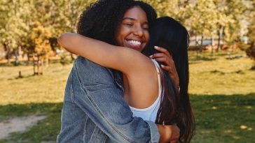 two women hugging in park