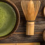 aerial view of cup of matcha tea and bamboo stirring utensils