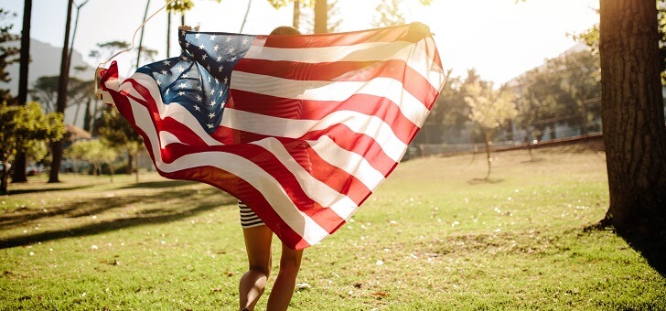 rear shot of woman draped in american flag