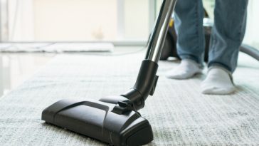 woman's feet while vacuuming rug