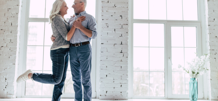 happy older couple embracing in empty house