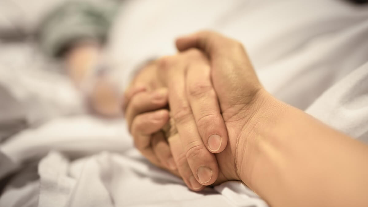 person holding mother's hand after well-lived life