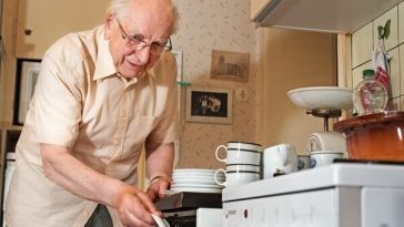 elderly man stacking dishwasher