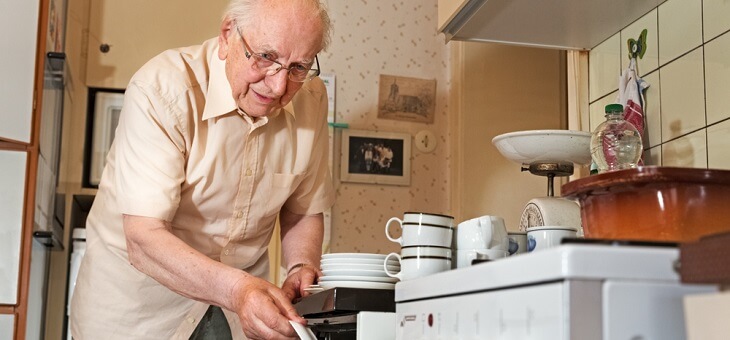 elderly man stacking dishwasher