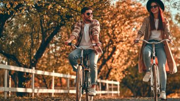 couple riding bikes in autumn foliage