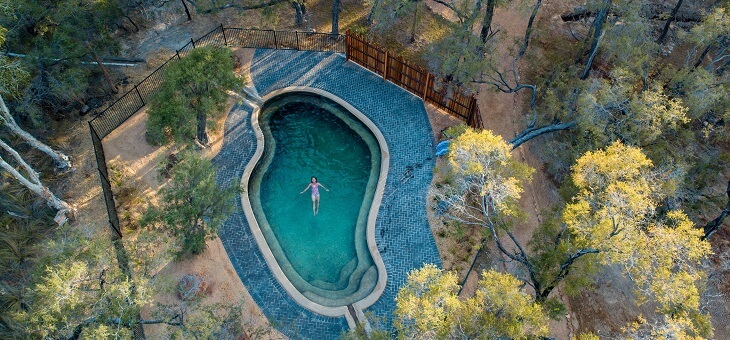 aerial shot of woman in pool in cairns bushland