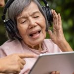 elderly lady wearing headphones and singing