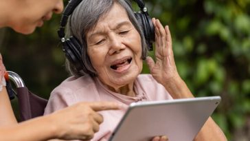 elderly lady wearing headphones and singing