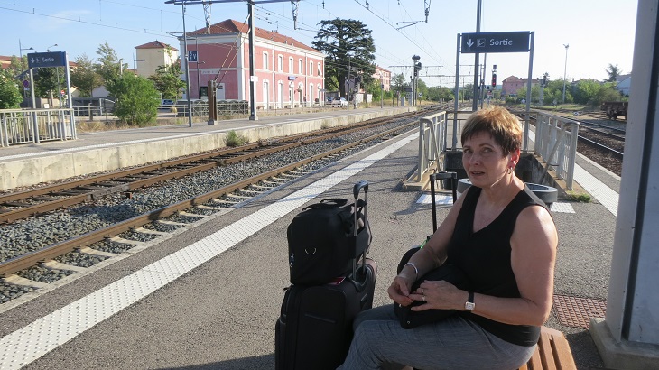 woman sitting on empty train platform