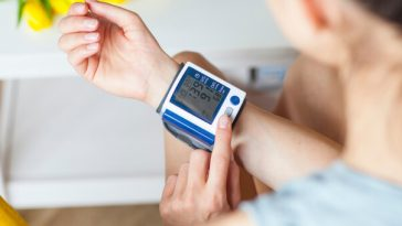 woman using blood pressure monitor