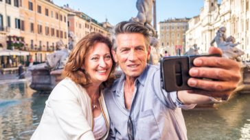 happy couple taking selfie on venetian gondola