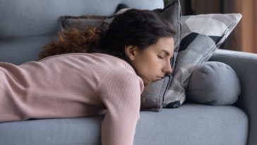 woman napping on couch lying on stomach