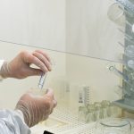 scientist in full protective gear testing liquids in lab