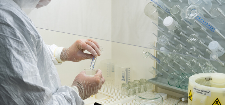 scientist in full protective gear testing liquids in lab