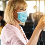 older woman wearing protective face mask on crowded bus 730