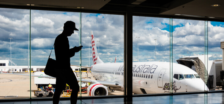 silhouette of man against indow with airliner outside