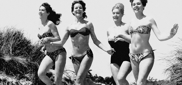 group of women running in different bathing suits