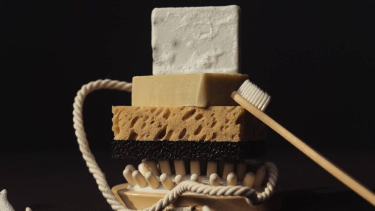 Soap, a sponge and a toothbrush on a black background