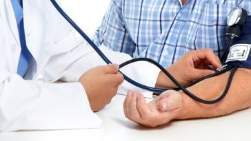 man having blood pressure tested by doctor