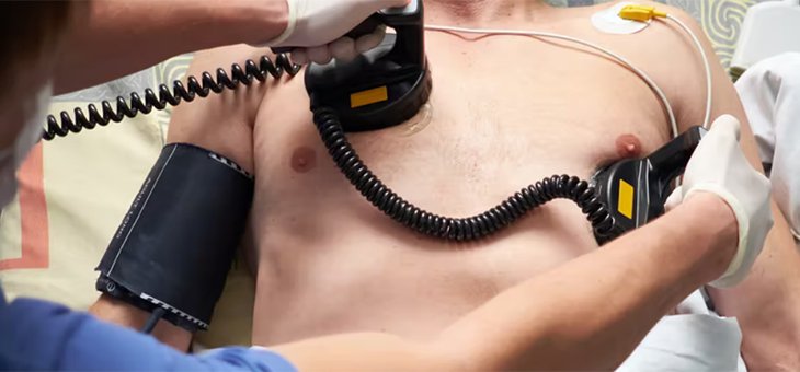 doctor applying defribulators to a mans chest