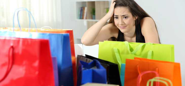 woman looking frustrated surrounded by shopping bags